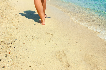 Fototapeta na wymiar beautiful legs on the sand by the sea