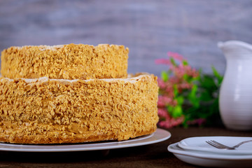 Homemade cake with crushed nuts and flowers on background