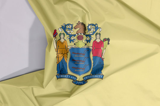 New Jersey fabric flag crepe and crease with white space, the states of America. The state coat of arms on buff color.