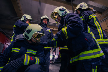 Portrait of group of firefighters wearing protective uniform inside the fire station