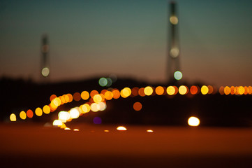 abstract photo out of focus, illumination of a night city and a high cable-stayed bridge, bokeh from headlights of cars