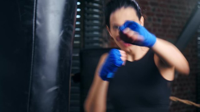 Closeup brunette woman fighting in gloves enjoying martial arts battle without rules
