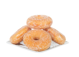 Square plate with sugar coated  donuts stacked, isolated on white