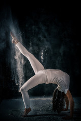 young woman doing yoga poses with flour