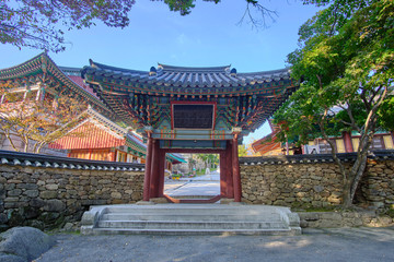 Fototapeta premium Scenic view of entrance to buddhistic temple in Jirisan national park in Republic of Korea. Beautiful summer sunny look of gate in asian style to religion object in South Korea