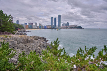 Scenic view of awesome rocky beach, sea and skyscrapers in Busan in South Korea. Beautiful summer cloudy look of relax place in resort city of Republic of Korea