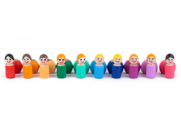 A close-up of a children's toy made of natural wood in the form of little people of different colors with a smile is standing in an even row on a white isolated background. Teamwork concept. 