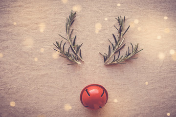 Minimal reindeer made from rosemary and red decor bell, Christmas hipster festive background