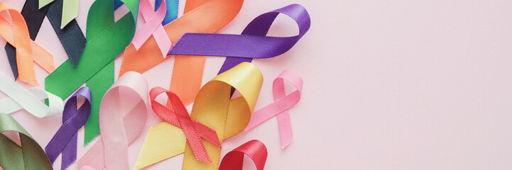colorful ribbons on pink panoramic banner background, cancer awareness, World cancer day, Autism...