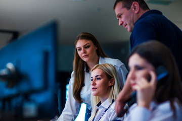 Security guards working in surveillance room. Female security guard with portable transmitter...