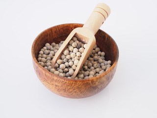 dried food with white pepper in wooden bowl isolated on white background.