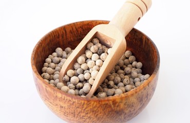 White pepper in wooden bowl isolated on white backgroud.