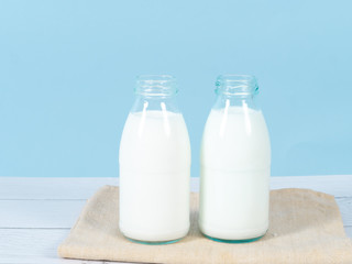 Milk bottle on table with blue background.