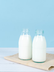 Milk bottle on table with blue background.