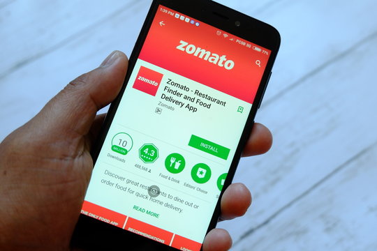 BANDAR SERI BEGAWAN,BRUNEI - JULY 25TH,2018 : A male hand holding smartphone with Zomato app on an android Google Play Store.