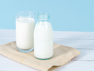Milk bottle on table with blue background.