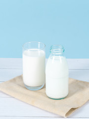 Milk bottle on table with blue background.