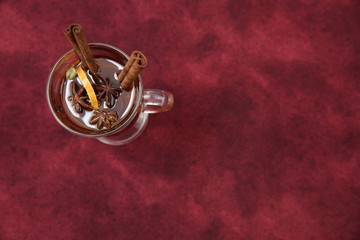 mulled wine hot drink or tea with spices on a red background. Isolated. Traditional winter drink. Christmas concept, background, banner, menu.. Flat lay. Top view. With copy space for text.