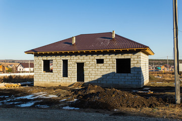 Fototapeta na wymiar House under construction from a foam block in a cottage village. Autumn, sunny