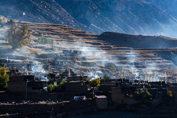 Local village on hill in the morning with smoke from kitchen, Pisang, Napal