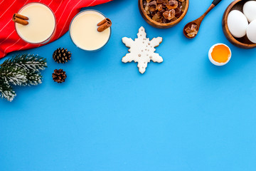 Make festive drink eggnog - ingredients on blue background top view frame copy space