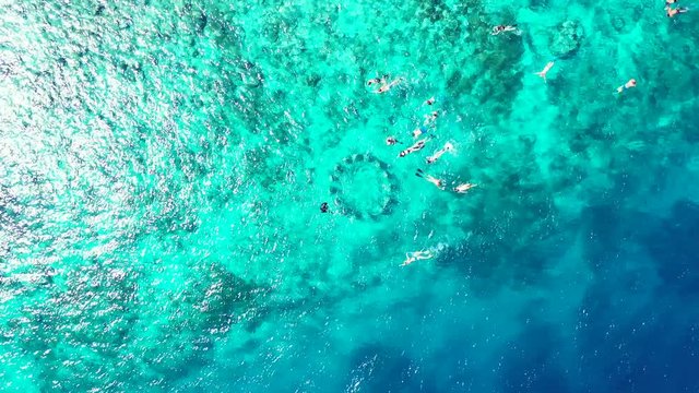 Astonishing aerial view of Maldives waters, with people enjoying watersports. Tropical travel destination and luxury holiday concept