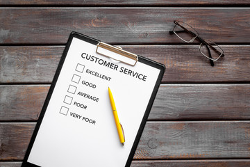 Customer service form on dark wooden background top view copy space