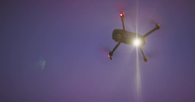 UAV drone orbiting in the sky shining a search spotlight at night, drone technology used for the good of humanity