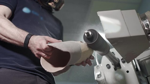 Production of a prosthetic leg. A man creates a part of the leg above the knee. Grinds the plastic part of the leg on a lathe. New body part.