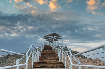 Fototapeta premium Sunrise at top of mount and stair-steps and pergola, photo taken in nature public park, vicinity of Eilat - famous tourist resort and recreational city in Israel