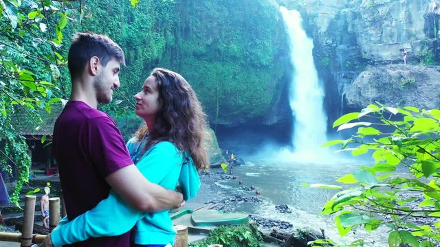 teenage couple teasing each other before kiss. tropical jungle with waterfall. Bali, Indonesia