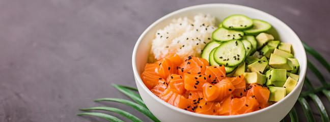 Hawaiian salmon bowl with cucumbers, avocado, sesame seeds and rice. Top view, overhead, flat lay, mock up, template. Healthy food concept