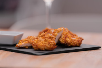 Pieces of chicken placed in a kind of black tray