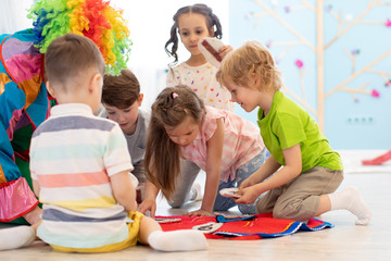 clown entertains preschool kids group on party