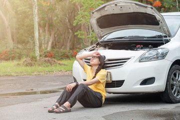 Young stressed woman having trouble with her car breakdown on the road and she waiting someone can...