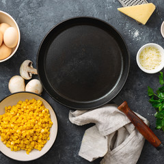 Healthy breakfast table with empty cooking pan and ingredient for cooking. Mushrooms, corn, eggs, spinach and cheese on dark stone background top view