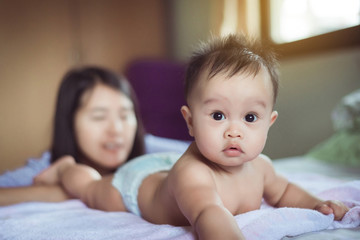 Cute baby crawling at bedroom,Mother take care and support,Childhood and baby care concept