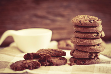 Close up stacked chocolate chip cookies on  napkin with wooden background