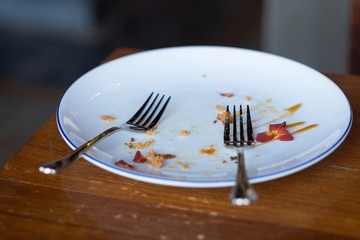 Spoon sparring in a white dish after eating the cake