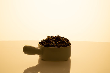 Jar full of coffee seeds beige background