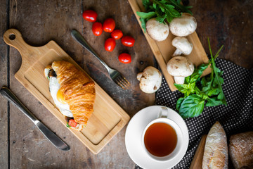 breakfast croissant with fried egg with herbs and mushrooms on a beautiful background