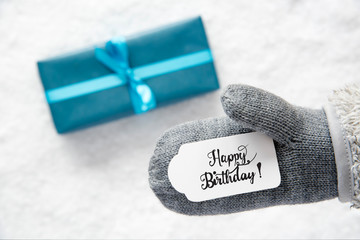 Label With English Calligraphy Calligraphy Happy Birthday. Gray Glove With Turquoise Gift And Snow Background