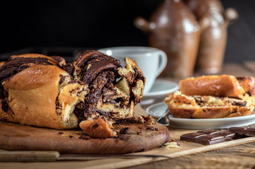 Swirl cake with chocolate on wooden background