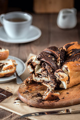 Swirl cake with chocolate on wooden background