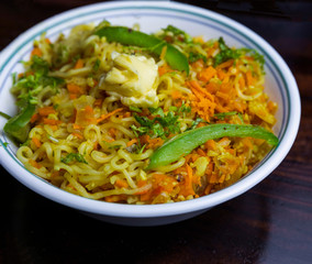 A bowl of Noodles with vegetables and butter topping