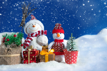 Snowman in a snowdrift with gifts for Christmas and New year