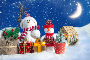 Snowman in a snowdrift with gifts for Christmas and New year