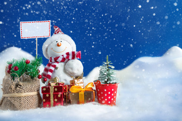 Snowman in a snowdrift with gifts for Christmas and New year