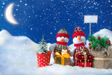 Snowman in a snowdrift with gifts for Christmas and New year