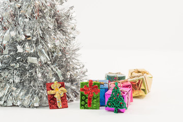 Silver coloured Christmas tree with a red star on top and isolated against a white background.